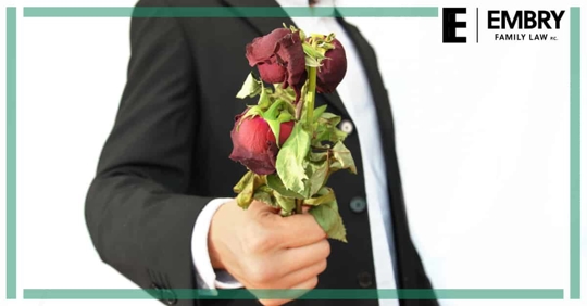 man holding dead roses