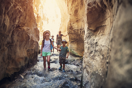 parent and children walking through a canyon on vacation