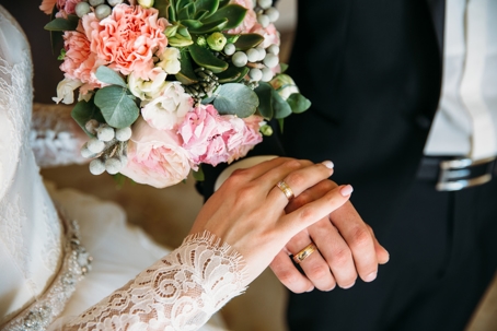 bride and groom showing wedding rings