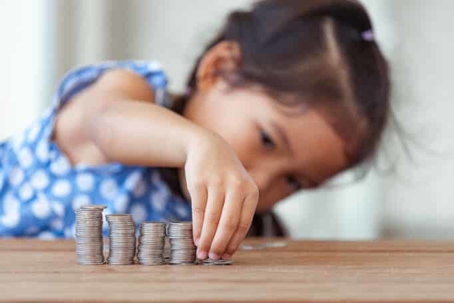 young girl stacking coins